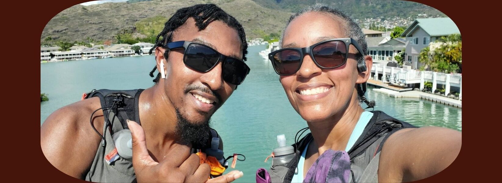 Kimberlee Middleton and her son taking a selfie during the Honolulu Marathon, with the water pier and mountains in the background.